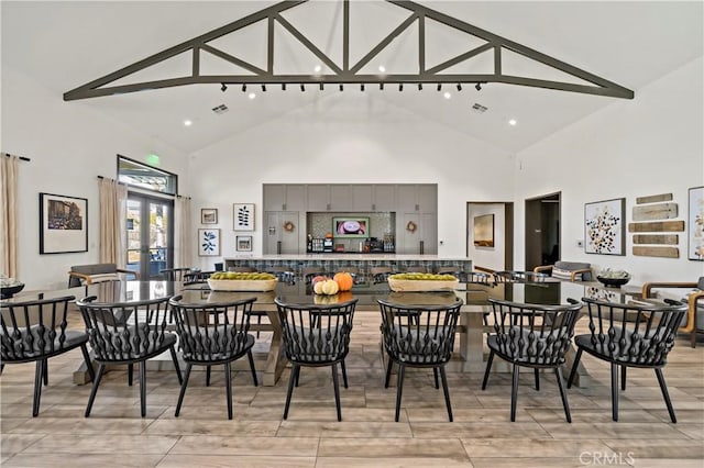 dining room with french doors, beam ceiling, high vaulted ceiling, and light hardwood / wood-style flooring