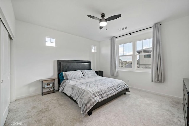 carpeted bedroom featuring ceiling fan, a closet, and multiple windows