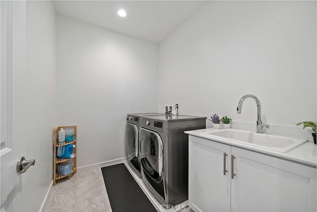 laundry room with sink, washing machine and dryer, and cabinets