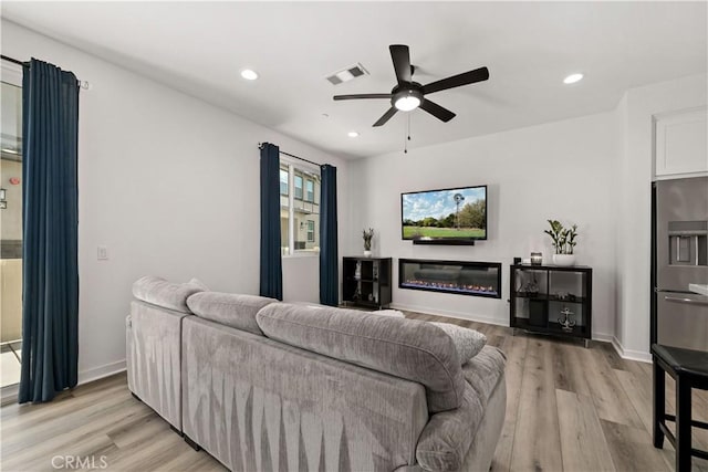 living room with light hardwood / wood-style flooring and ceiling fan