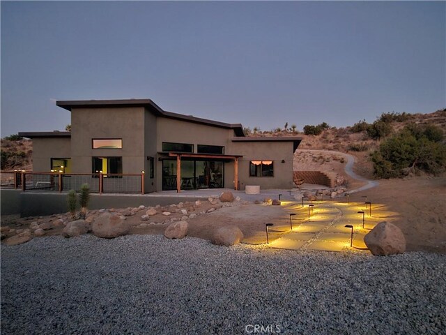 back of property featuring stucco siding, a patio, and fence