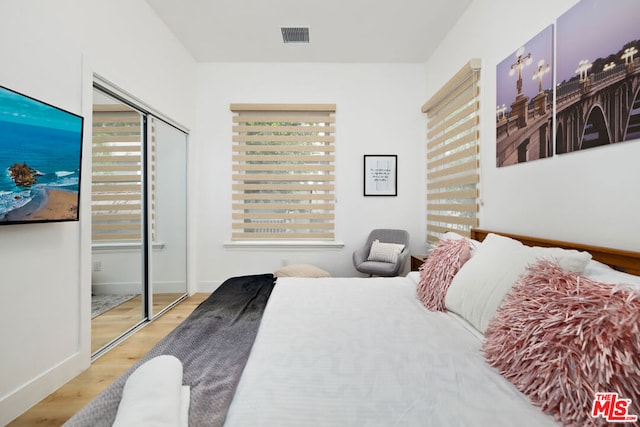 bedroom with light wood-type flooring and a closet