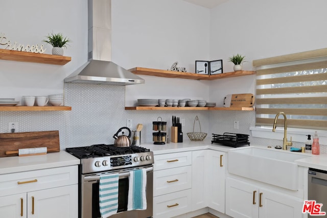 kitchen with appliances with stainless steel finishes, wall chimney exhaust hood, white cabinets, and tasteful backsplash