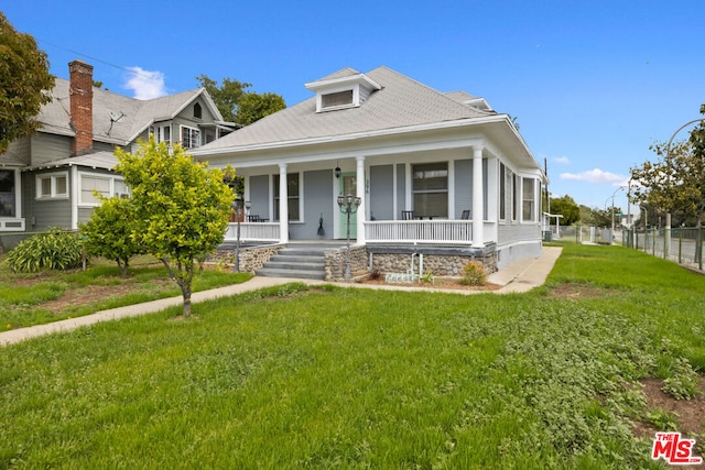 view of front of house featuring covered porch and a front lawn