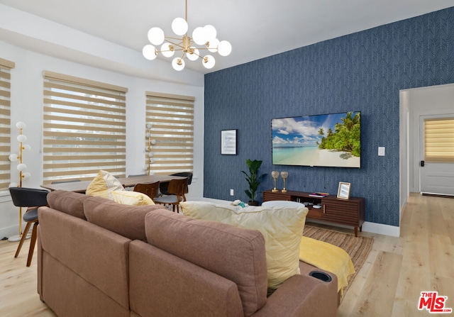 living room with light hardwood / wood-style floors and an inviting chandelier