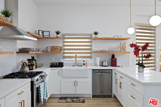 kitchen featuring white cabinets, appliances with stainless steel finishes, decorative light fixtures, decorative backsplash, and sink