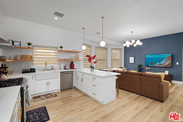 kitchen featuring white cabinets, appliances with stainless steel finishes, decorative light fixtures, sink, and kitchen peninsula