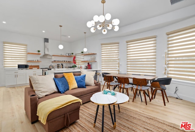 living room with light hardwood / wood-style flooring and a notable chandelier