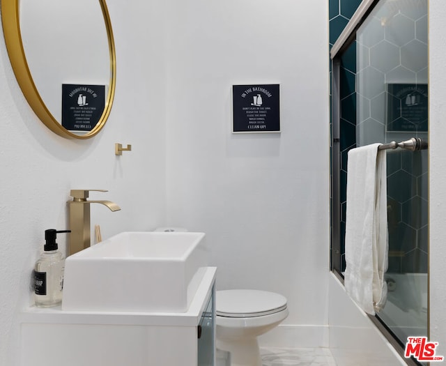 full bathroom featuring toilet, shower / bath combination with glass door, and sink