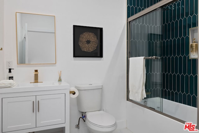 full bathroom featuring toilet, vanity, and shower / bath combination with glass door