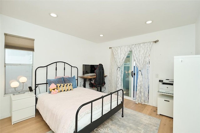 bedroom with light hardwood / wood-style flooring and multiple windows