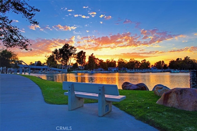 view of property's community with a yard and a water view