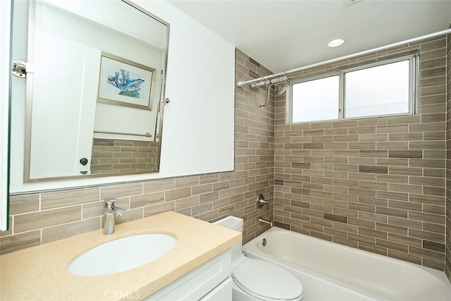 full bathroom with toilet, tiled shower / bath, backsplash, and vanity