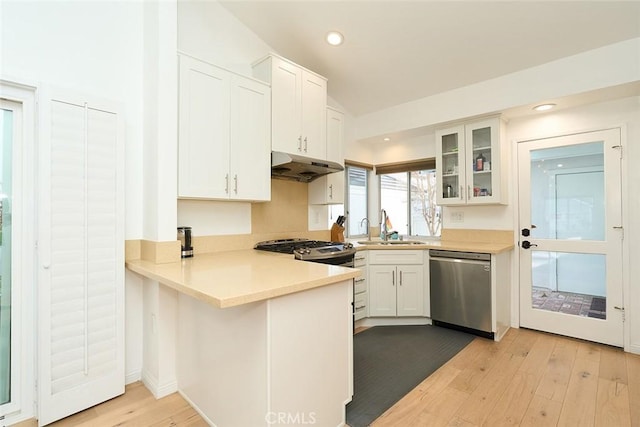 kitchen with white cabinets, dishwasher, sink, kitchen peninsula, and light hardwood / wood-style flooring