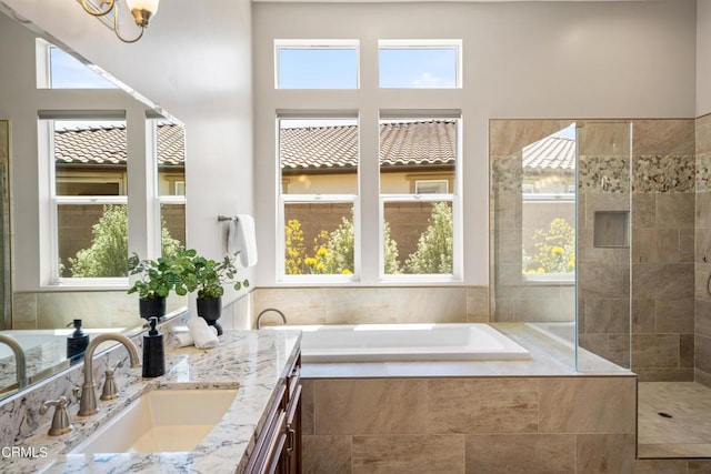 bathroom with tiled tub and vanity