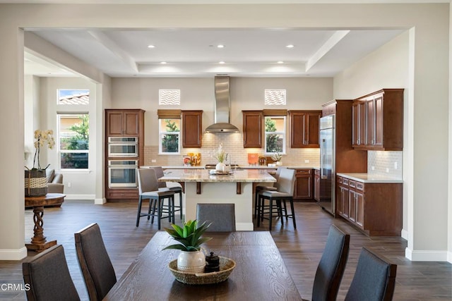 dining room featuring dark hardwood / wood-style flooring, a high ceiling, and a tray ceiling