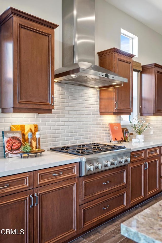 kitchen with dark hardwood / wood-style floors, stainless steel gas cooktop, backsplash, and wall chimney range hood