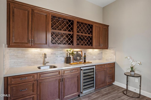 bar featuring decorative backsplash, sink, and beverage cooler