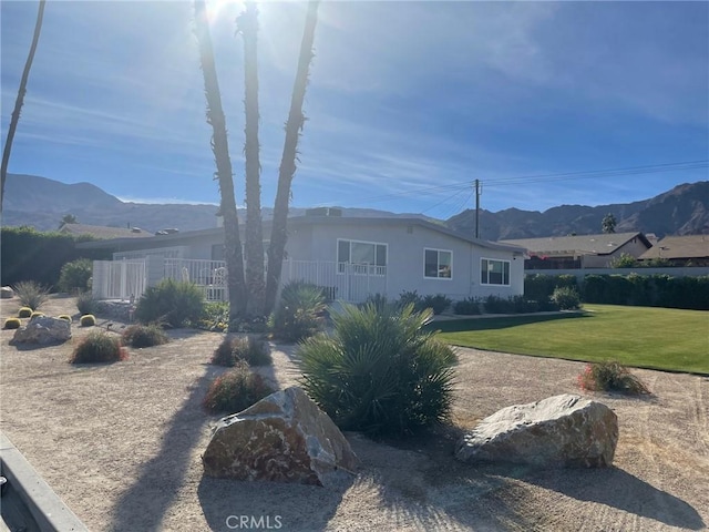 rear view of property featuring a mountain view and a lawn