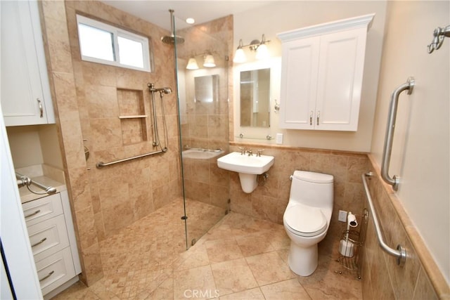 bathroom with toilet, a tile shower, tile walls, tile patterned floors, and sink