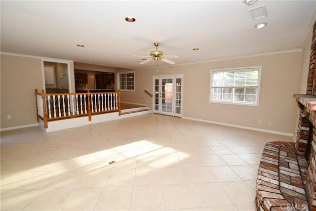 unfurnished living room with ceiling fan, light tile patterned floors, a large fireplace, and crown molding