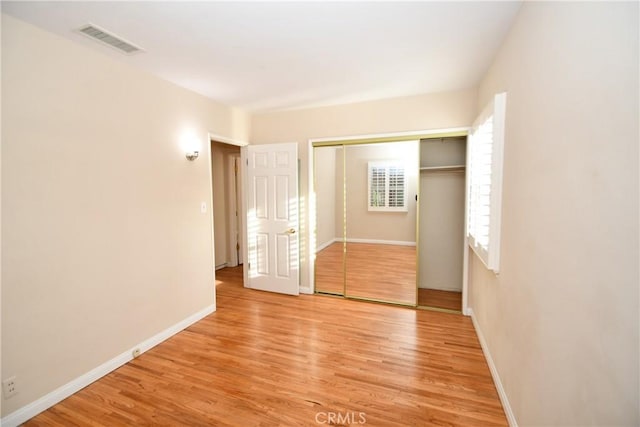 unfurnished bedroom with a closet and light hardwood / wood-style floors