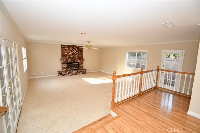 unfurnished living room with ceiling fan, a fireplace, and ornamental molding