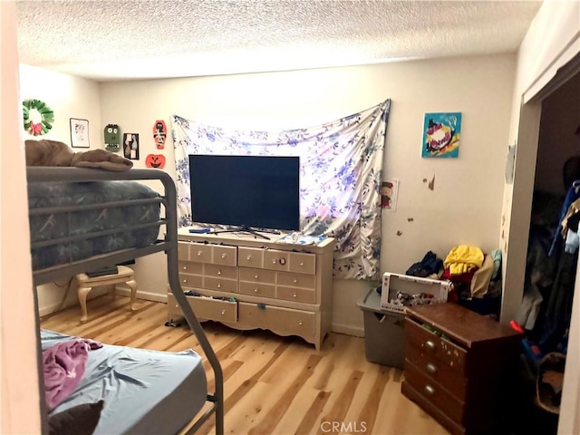 bedroom featuring a textured ceiling and light hardwood / wood-style floors