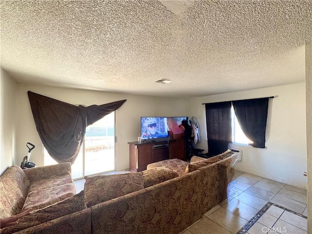 living room with a textured ceiling and light tile patterned floors