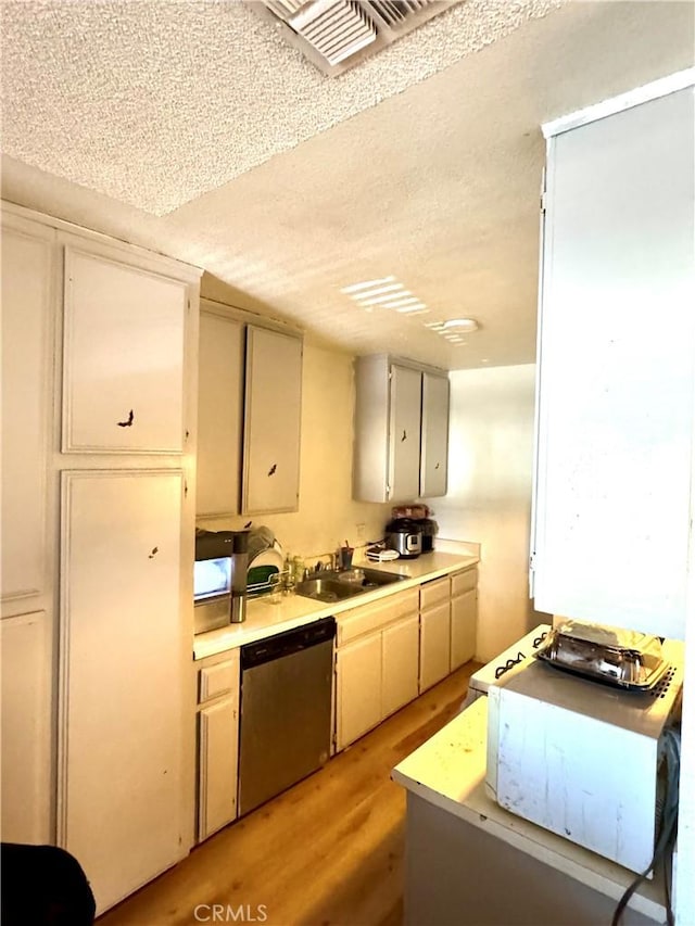 kitchen with dishwasher, sink, a textured ceiling, and light hardwood / wood-style flooring