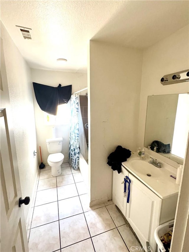 full bathroom with shower / bath combo with shower curtain, a textured ceiling, toilet, and tile patterned flooring