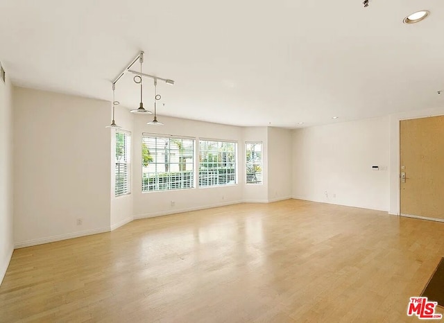 spare room featuring rail lighting and light wood-type flooring