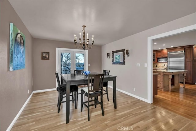 dining room featuring light hardwood / wood-style flooring and an inviting chandelier