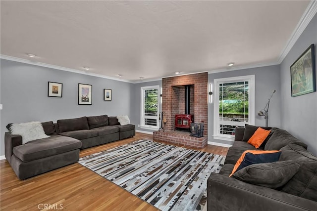 living room featuring hardwood / wood-style flooring, a wood stove, and crown molding