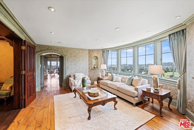 living room with a wealth of natural light, wood-type flooring, and crown molding