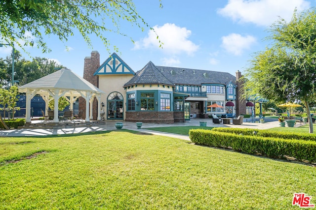 back of house with a gazebo and a yard