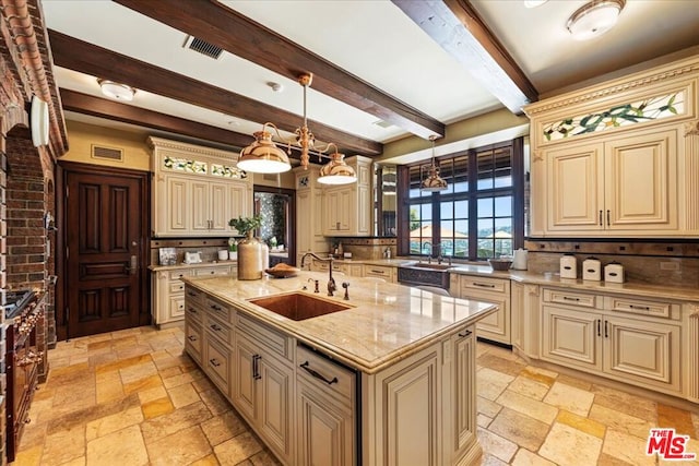 kitchen featuring cream cabinetry, a center island with sink, pendant lighting, beam ceiling, and sink