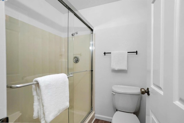 bathroom featuring an enclosed shower and toilet