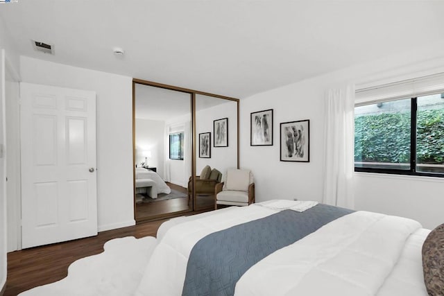 bedroom with a closet and dark wood-type flooring