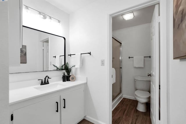 bathroom featuring walk in shower, vanity, wood-type flooring, and toilet