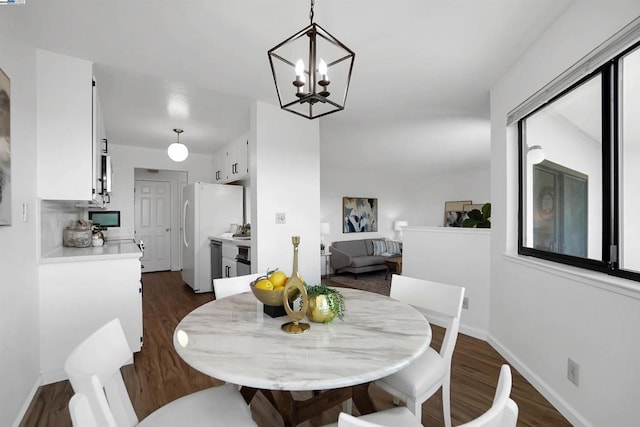 dining area with dark hardwood / wood-style flooring and a notable chandelier