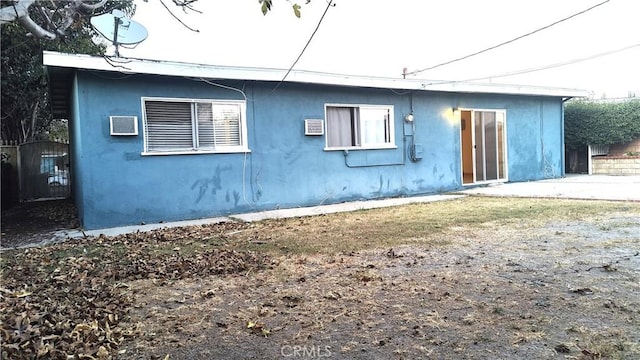 back of property featuring an AC wall unit and a patio