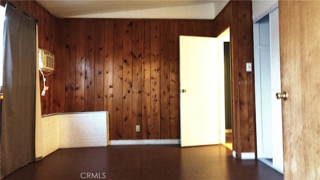 spare room with a wall unit AC and wooden walls