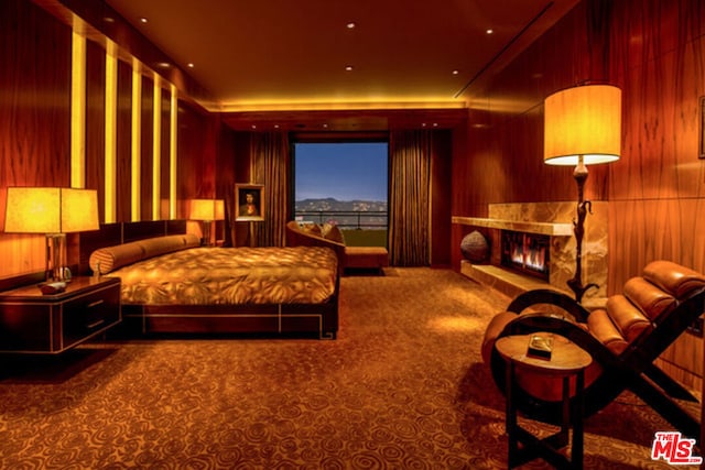 bedroom featuring carpet flooring, a fireplace, and wooden walls