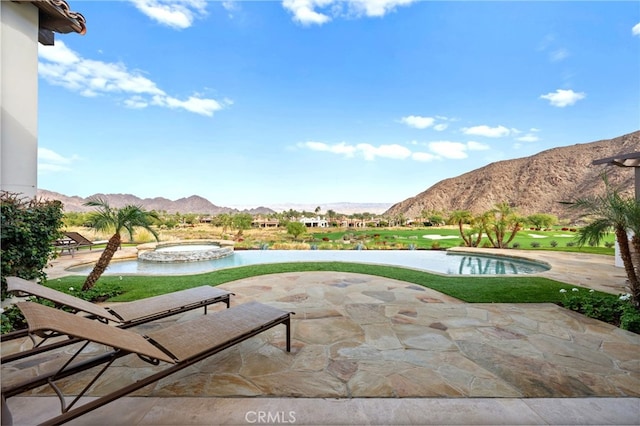 view of patio with a swimming pool with hot tub and a mountain view