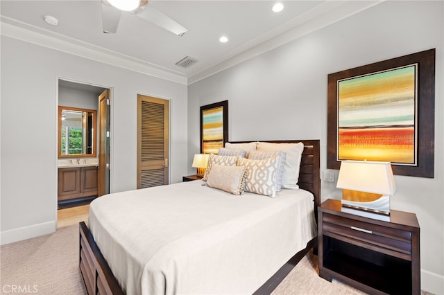 carpeted bedroom featuring ensuite bathroom, sink, ornamental molding, ceiling fan, and a closet