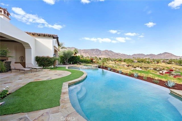 view of swimming pool featuring an in ground hot tub, a mountain view, and a patio