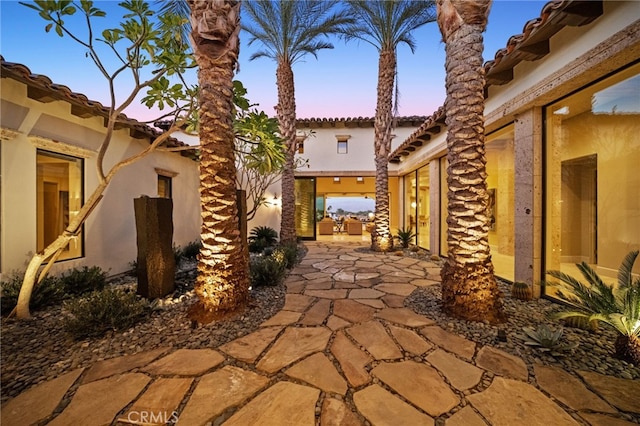 property exterior at dusk with a patio area