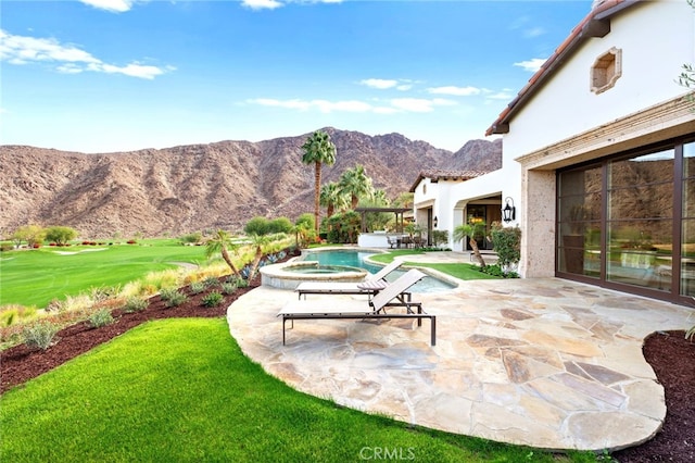 view of patio / terrace featuring a mountain view and an in ground hot tub