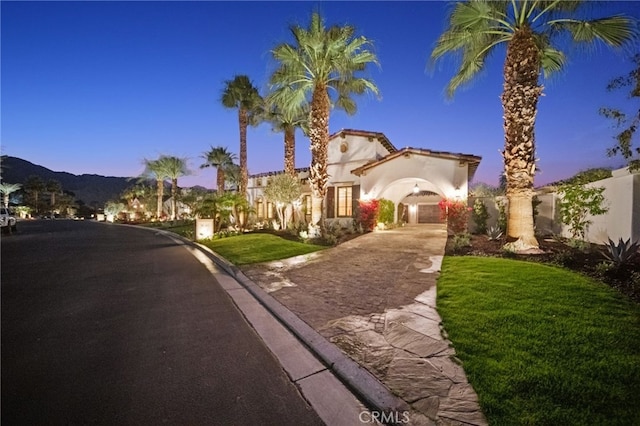 mediterranean / spanish house with a yard and a mountain view